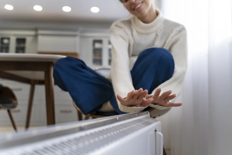 Smiley woman sitting near heater home